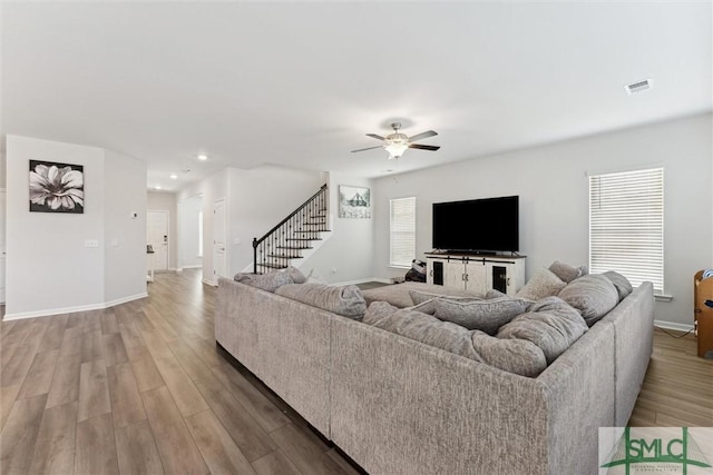 living room with ceiling fan and light wood-type flooring