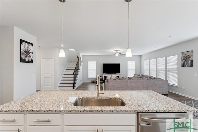 kitchen featuring stainless steel dishwasher, pendant lighting, white cabinets, and sink