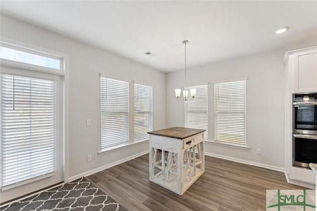 dining room with dark wood-type flooring and a notable chandelier