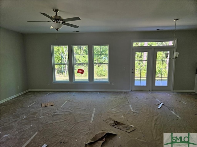 unfurnished room with baseboards, ceiling fan, visible vents, and a healthy amount of sunlight