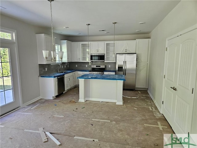 kitchen featuring glass insert cabinets, white cabinetry, a sink, backsplash, and stainless steel appliances
