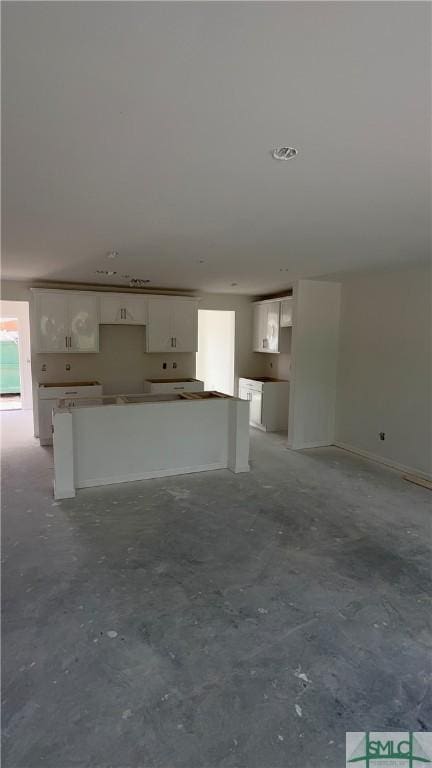 unfurnished living room featuring unfinished concrete flooring