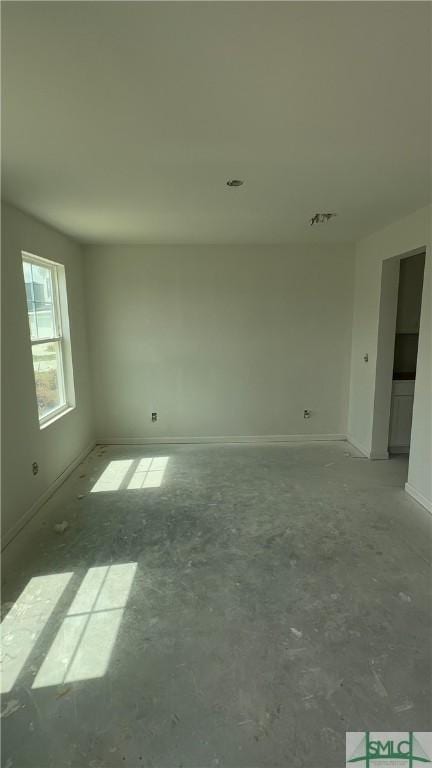 unfurnished room with baseboards