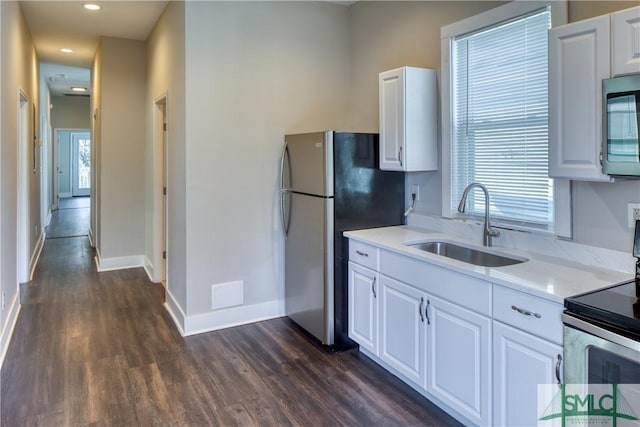 kitchen featuring plenty of natural light, stainless steel appliances, white cabinetry, and sink