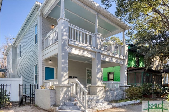 view of front of house featuring a balcony, covered porch, and a sunroom