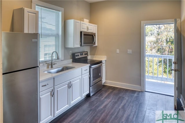 kitchen with white cabinets, appliances with stainless steel finishes, sink, and dark hardwood / wood-style floors