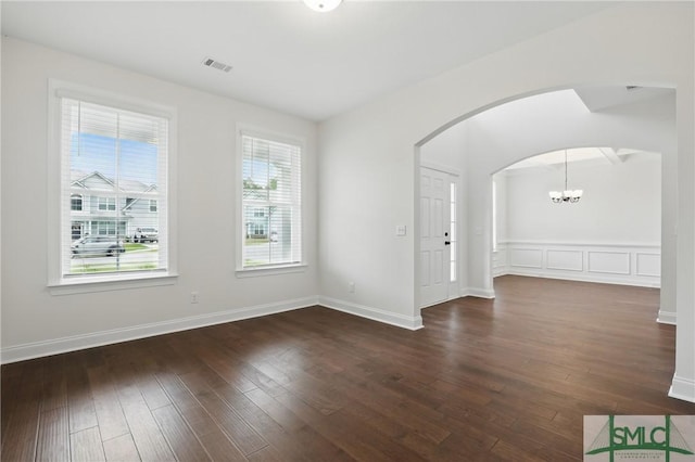 106 Liam Ct, Guyton, GA 31312 - empty room with arched walkways, a chandelier, hardwood / wood-style flooring, and baseboards