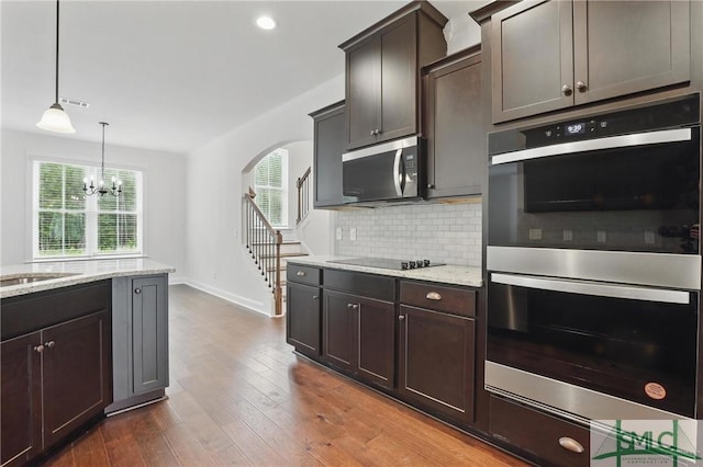 106 Liam Ct, Guyton, GA 31312 - kitchen with appliances with stainless steel finishes, light stone countertops, tasteful backsplash, baseboards, and a chandelier