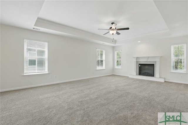 106 Liam Ct, Guyton, GA 31312 - unfurnished living room featuring a raised ceiling, ceiling fan, a brick fireplace, baseboards, and carpet flooring