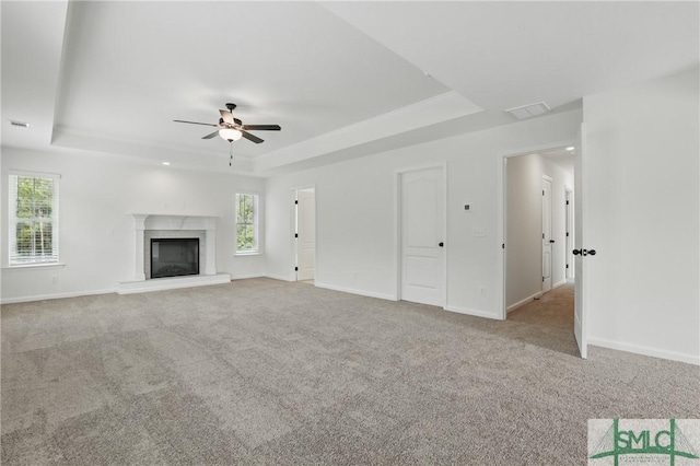 106 Liam Ct, Guyton, GA 31312 - unfurnished living room with a raised ceiling, a ceiling fan, a brick fireplace, carpet flooring, and baseboards