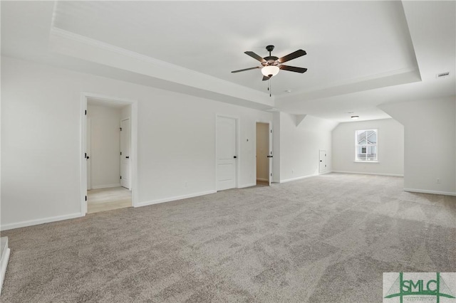 106 Liam Ct, Guyton, GA 31312 - unfurnished living room featuring a raised ceiling, light carpet, ceiling fan, baseboards, and ornamental molding