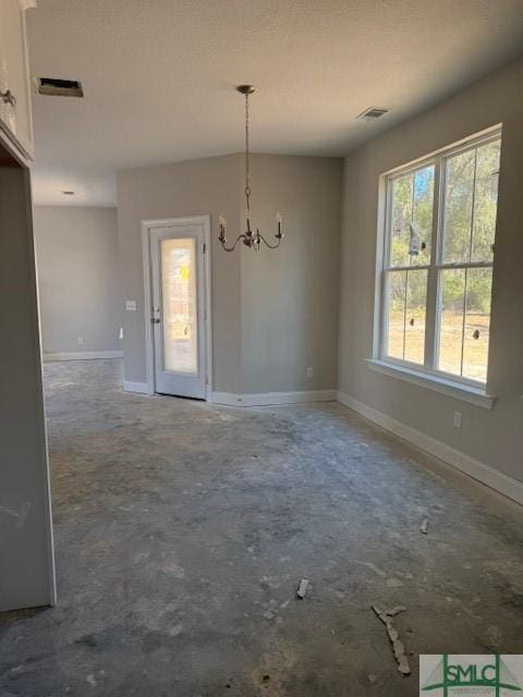 unfurnished dining area featuring a notable chandelier, unfinished concrete flooring, visible vents, and baseboards