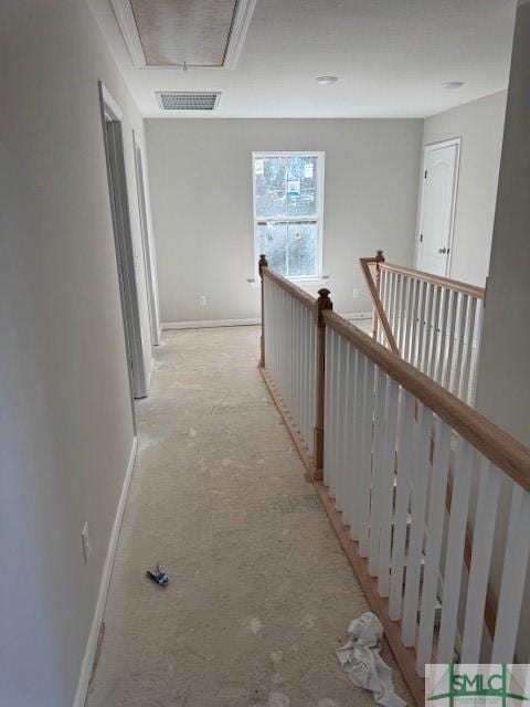 hallway featuring baseboards, an upstairs landing, visible vents, and attic access