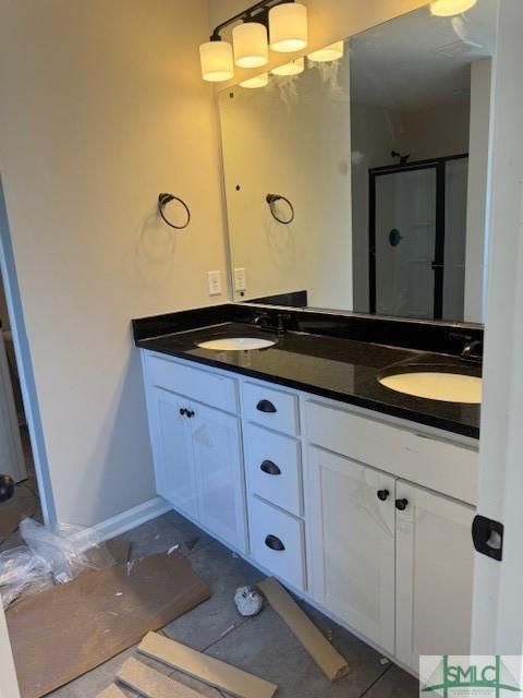 bathroom featuring a shower with shower door and vanity