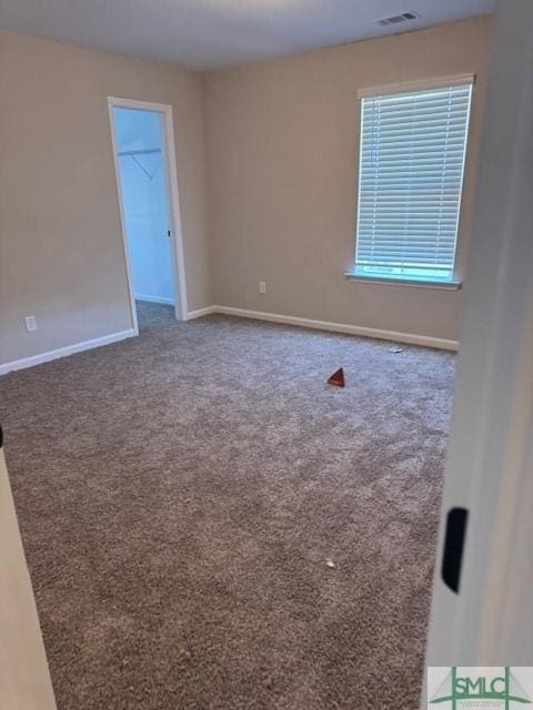 carpeted empty room with visible vents and baseboards