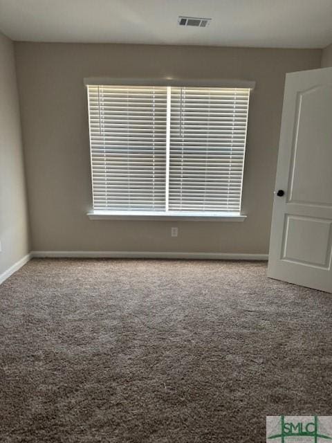 carpeted spare room featuring visible vents and baseboards