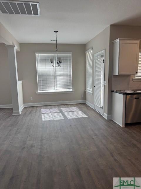 unfurnished dining area featuring plenty of natural light, visible vents, and dark wood finished floors