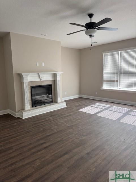 unfurnished living room with dark wood finished floors, baseboards, and a premium fireplace