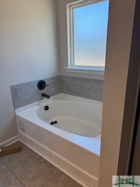 bathroom with tile patterned floors and a bath