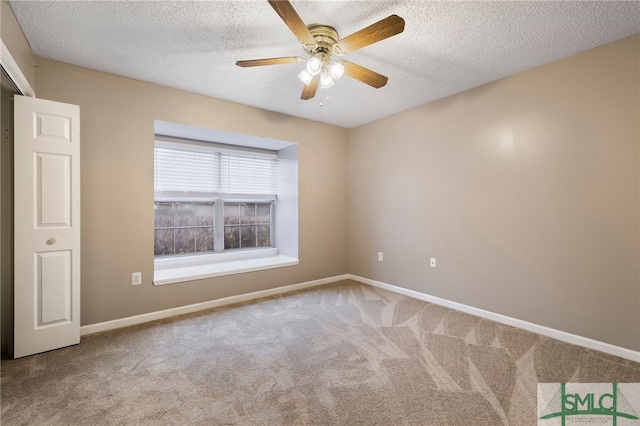 carpeted spare room featuring ceiling fan and a textured ceiling