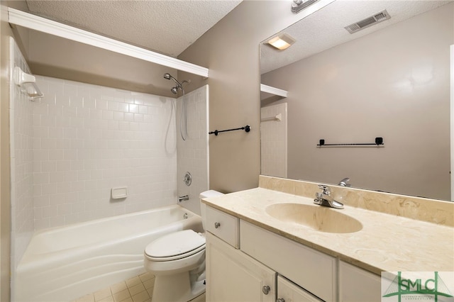 full bathroom with toilet, tiled shower / bath, tile patterned floors, a textured ceiling, and vanity