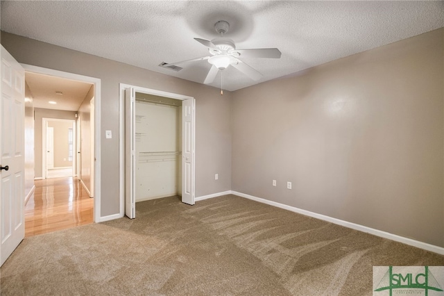 unfurnished bedroom featuring ceiling fan, a closet, carpet, and a textured ceiling