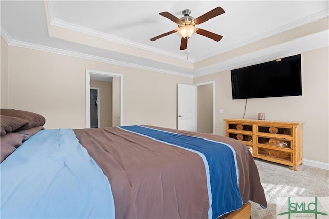 carpeted bedroom with crown molding, a tray ceiling, and ceiling fan