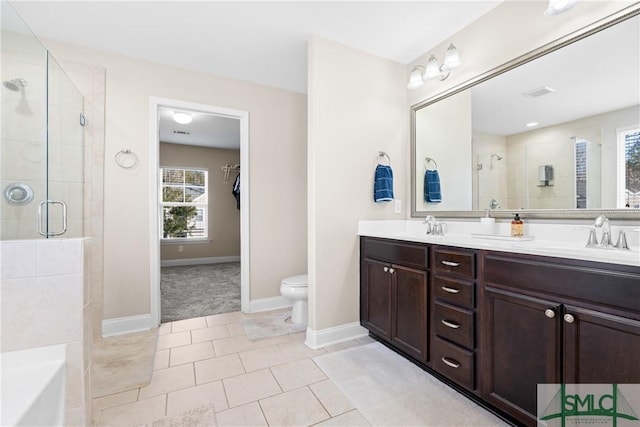 bathroom with vanity, toilet, tile patterned flooring, and a shower with door