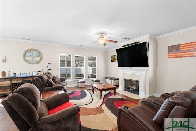 living room featuring ornamental molding, a premium fireplace, and ceiling fan