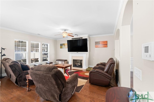 living room with ornamental molding, ceiling fan, and dark hardwood / wood-style flooring