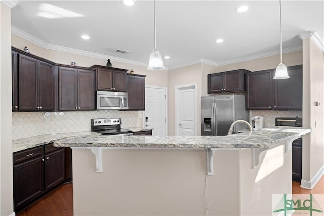 kitchen featuring hanging light fixtures, a center island with sink, and appliances with stainless steel finishes