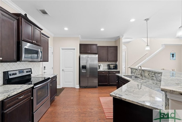 kitchen featuring sink, dark brown cabinets, dark hardwood / wood-style floors, pendant lighting, and stainless steel appliances