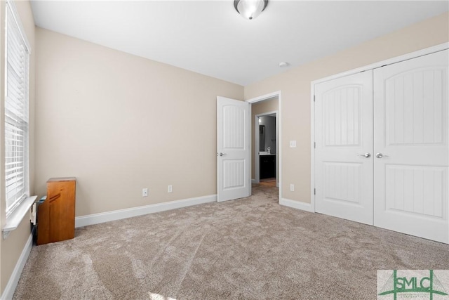 unfurnished bedroom with light colored carpet and a closet