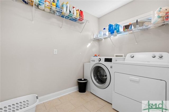 laundry area with washing machine and clothes dryer and light tile patterned floors