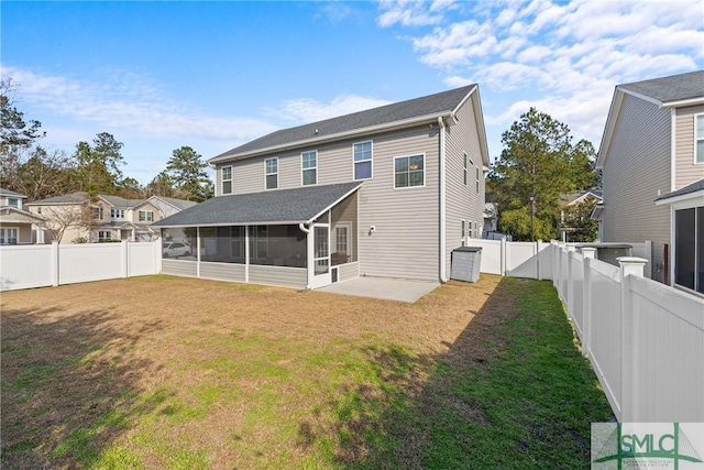 back of house with a lawn, a sunroom, and a patio