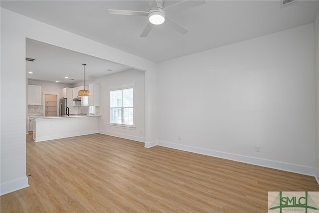 unfurnished living room with light hardwood / wood-style floors and ceiling fan