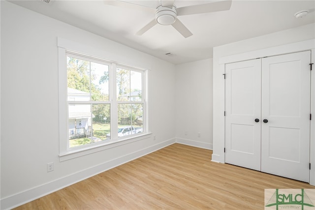 unfurnished bedroom featuring light wood-type flooring, ceiling fan, and a closet