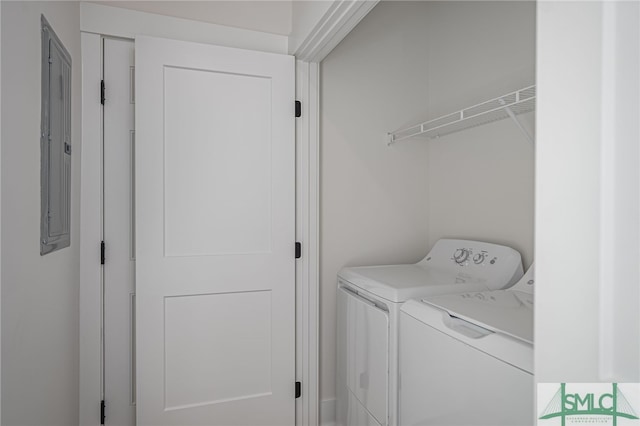 laundry room featuring electric panel and washing machine and clothes dryer