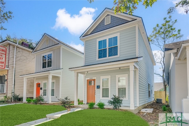 view of front of house with central AC unit and a front yard