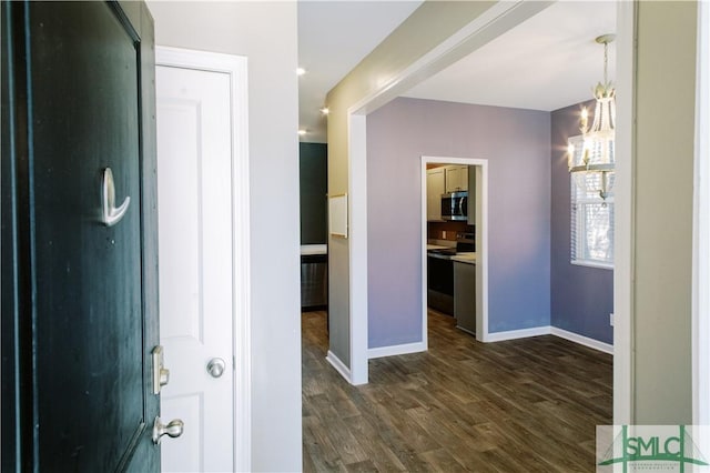 foyer entrance featuring dark wood-type flooring and a chandelier