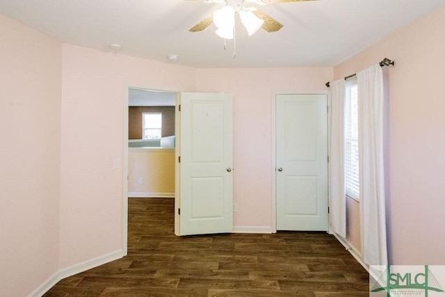 unfurnished bedroom with ceiling fan and dark wood-type flooring