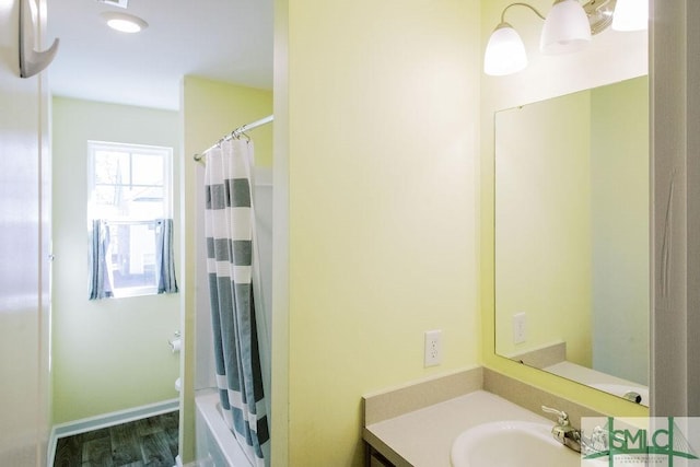 bathroom with toilet, vanity, and wood-type flooring