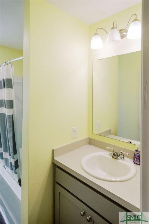 bathroom featuring walk in shower and vanity