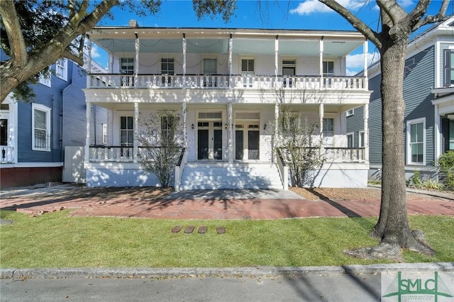 view of front of home featuring a front lawn and a balcony