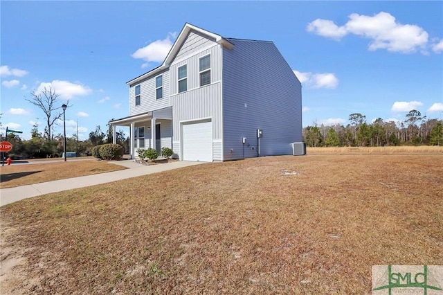 exterior space featuring a front yard, cooling unit, a porch, and a garage