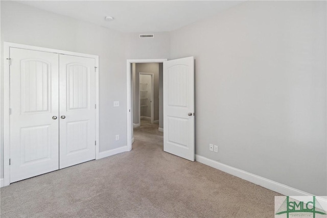 unfurnished bedroom featuring a closet and light carpet