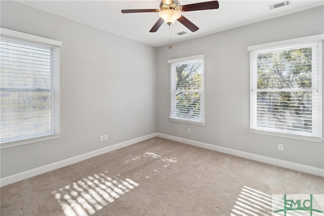 carpeted empty room with ceiling fan and a healthy amount of sunlight