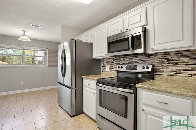 kitchen featuring stainless steel appliances, white cabinets, and hanging light fixtures