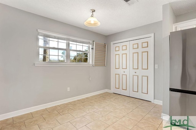 interior space featuring light tile patterned floors and a textured ceiling