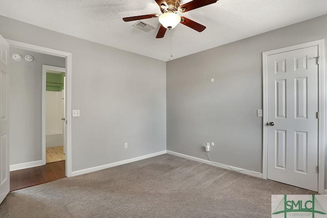 empty room with a textured ceiling, ceiling fan, and carpet floors